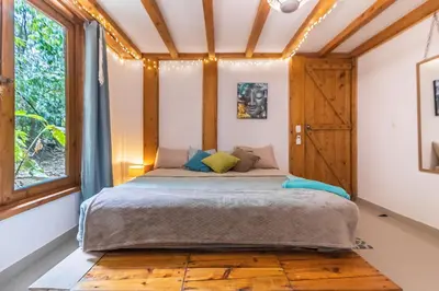 a bed in a room with a large window at Villas Wanderlust in Puntarenas