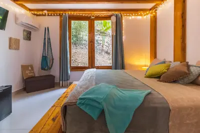 a bedroom with a large bed and a window at Villas Wanderlust in Puntarenas