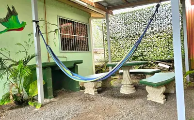 a hammock and a bench in front of a house at Hostel Cattleya - Monteverde, Costa Rica in Monteverde Costa Rica