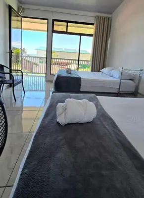 a hotel room with two beds and a towel on a rug at Hostel Cattleya - Monteverde, Costa Rica in Monteverde Costa Rica