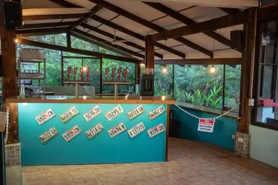 a restaurant with a counter in a room with windows at Hotel Aeropuerto in Alajuela City