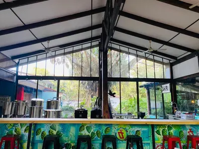 a restaurant with a counter with chairs and windows at Hotel Aeropuerto in Alajuela City