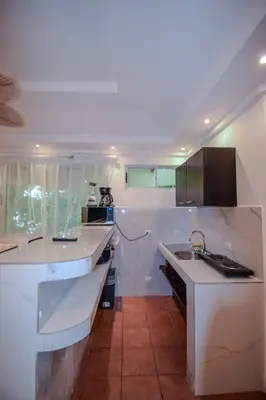 a white kitchen with a sink and a counter at Maravida Boutique Hotel & Resort in Tamarindo