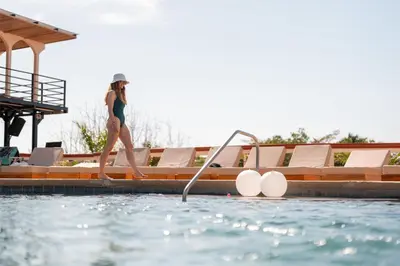 a woman is standing on the edge of a swimming pool at Maravida Boutique Hotel & Resort in Tamarindo