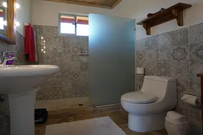 a bathroom with a toilet and a sink at El nido rojo in Sámara