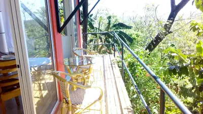 a balcony with two chairs and a window at El nido rojo in Sámara
