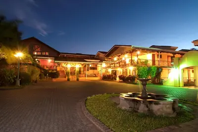 a building with a fountain in front of it at night at El Rodeo Estancia Boutique Hotel & Steakhouse in San José