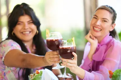 two women holding up glasses of wine at El Rodeo Estancia Boutique Hotel & Steakhouse in San José