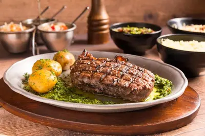 a plate of steak and vegetables on a table at El Rodeo Estancia Boutique Hotel & Steakhouse in San José