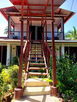 a staircase leading up to a house with a roof at Chinitas Eco Lodge in Tortuguero