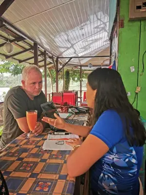a man and a woman sitting at a table at Chinitas Eco Lodge in Tortuguero