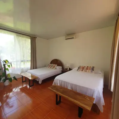 a bedroom with two beds and a window at Lumbres Arenal in Fortuna