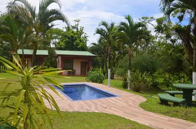 a house with a swimming pool in a garden at Lumbres Arenal in Fortuna