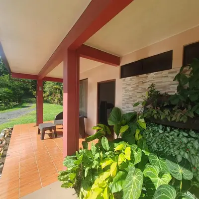 a house with a patio with plants in the yard at Lumbres Arenal in Fortuna