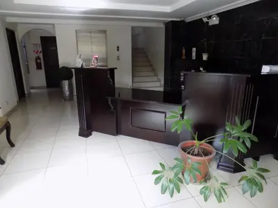 a living room with a staircase and a potted plant at Hotel Plaza Real Suites & Apartments San Jose in San José