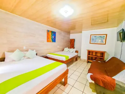 a hotel room with two beds and a fireplace at Cabinas Coco Alegre in Coco