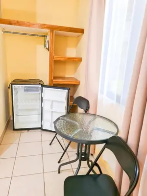 a glass table and two chairs in a room at Cabinas Coco Alegre in Coco