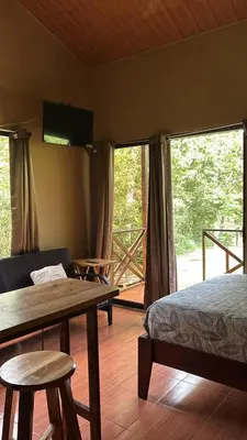 a bedroom with a bed and a table and a tv at Rio Celeste Dreams in Bijagua