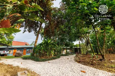 a gravel driveway in front of a house with trees at Rio Celeste Dreams in Bijagua