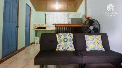 a couch with two pillows on it in a living room at Rio Celeste Dreams in Bijagua