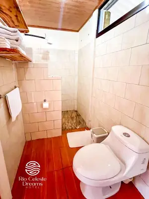 a bathroom with a white toilet and a window at Rio Celeste Dreams in Bijagua