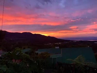 a sunset over a mountain range with a building at Hortensias Chalets Vara blanca in Heredia