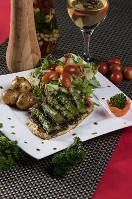 a plate of food with vegetables and a glass of wine at Hortensias Chalets Vara blanca in Heredia