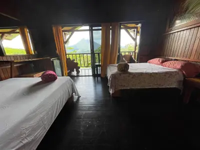 a bedroom with two beds and a balcony at Casa Torre Eco- Lodge in Fortuna