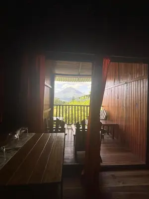 a room with a table and chairs and a balcony at Casa Torre Eco- Lodge in Fortuna