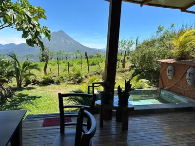 a patio with a table and chairs and a view of a mountain at Casa Torre Eco- Lodge in Fortuna