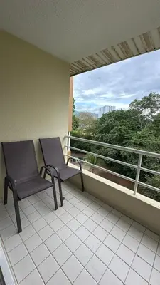 a chair sitting on a balcony with a window at Jaco Beach Penthouse in Jacó