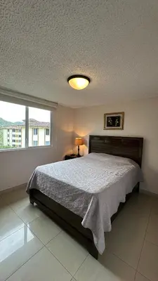 a bedroom with a bed and a large window at Jaco Beach Penthouse in Jacó