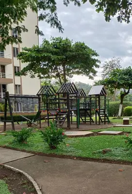 a playground in a park with trees and a building at Jaco Beach Penthouse in Jacó