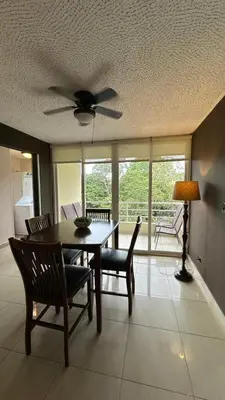 a dining room with a table and chairs and a ceiling fan at Jaco Beach Penthouse in Jacó