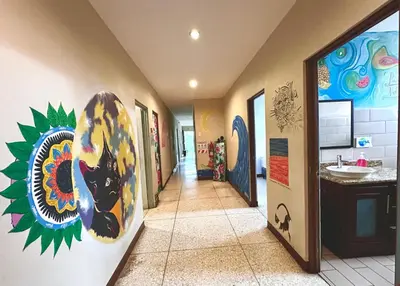 a hallway with a painting of a dog on the wall at Stray Cat Hostel in San José