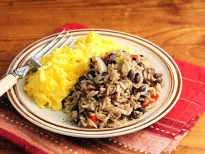 a plate of food with rice and beans and a fork at Stray Cat Hostel in San José