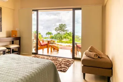 a bedroom with a bed and a sliding glass door at Vida Mountain Resort & Spa Adults Only in San Ramón
