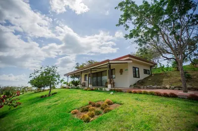 a small house with a green lawn in front of it at Vida Mountain Resort & Spa Adults Only in San Ramón