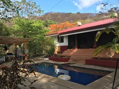 a house with a swimming pool in front of it at Guesthouse Casa Avi Fauna in Ocotal