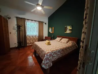 a bedroom with a bed and a ceiling fan at Guesthouse Casa Avi Fauna in Ocotal