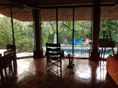 a room with a table and a chair in front of a wall at Guesthouse Casa Avi Fauna in Ocotal