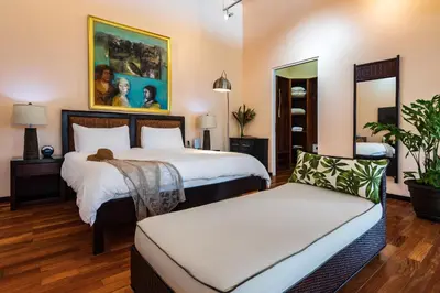 a hotel room with two beds and a couch at Gaia Hotel & Reserve- Adults Only in Manuel Antonio