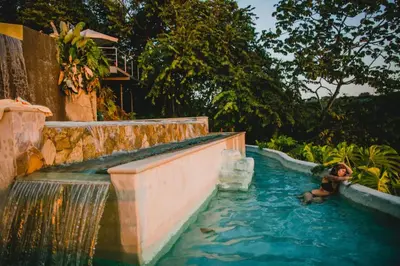 a man is in a swimming pool in a water park at Gaia Hotel & Reserve- Adults Only in Manuel Antonio