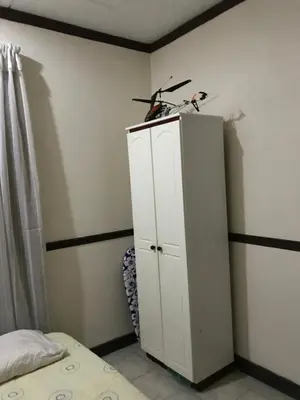 a bedroom with a white cabinet and a bed at Ruiselares in Puntarenas