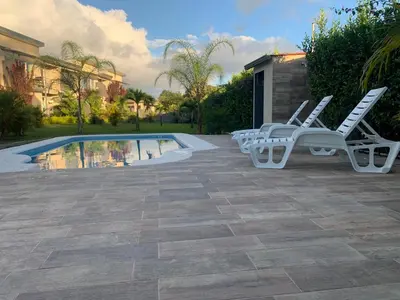 a group of chairs sitting next to a swimming pool at Apartamentos La Alborada Airport SJO in Alajuela City