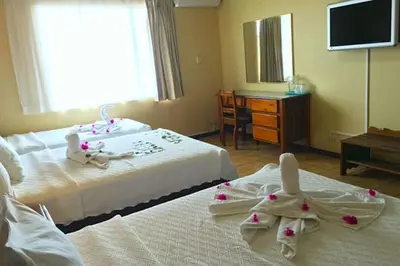 a hotel room with two beds with towels on them at Hotel Yadran Beach Resort in Puntarenas