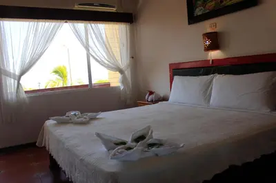 a bedroom with a bed with two towels on it at Hotel Yadran Beach Resort in Puntarenas