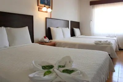 a hotel room with two beds with white sheets at Hotel Yadran Beach Resort in Puntarenas