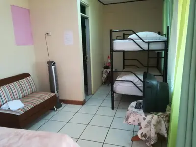 a room with two bunk beds and a tv at Belis in Alajuela City