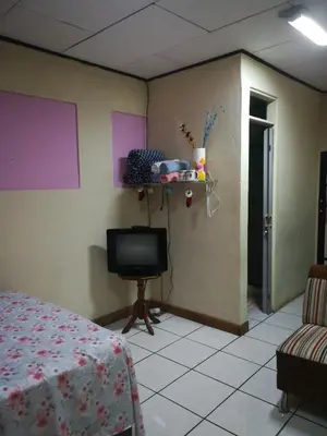 a room with a bed and a tv on a wall at Belis in Alajuela City